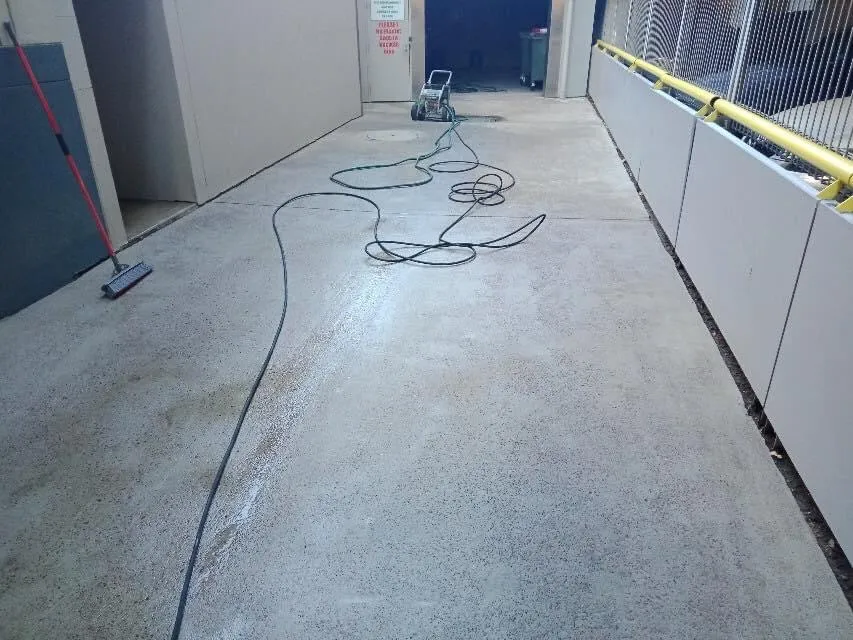Professionals pressure washing in progress to a slab